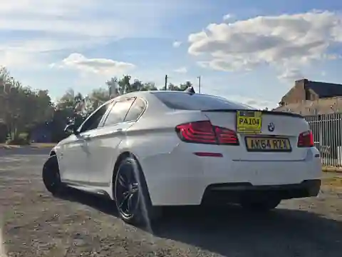 A white Pro Ride BMW photographed from the rear three-quarter angle in daylight