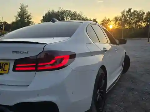 A white Pro Ride BMW photographed from the rear at sunset